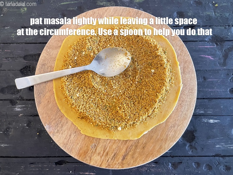 Step 58 – <meta charset="UTF-8" />Pat masala&nbsp;lightly while leaving a little space at the circumference. Use a spoon …
