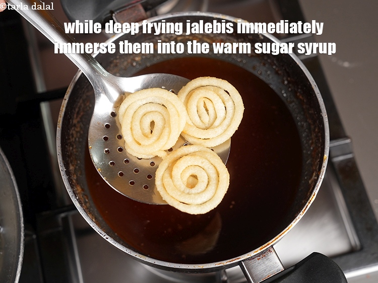 Step 27 – While deep frying jalebis immediately immerse them into the warm sugar syrup.