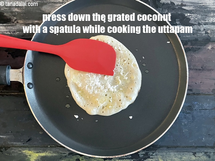 स्टेप 32 – उत्तपम पकाते समय कद्दूकस किये हुए नारियल को चम्मच से …