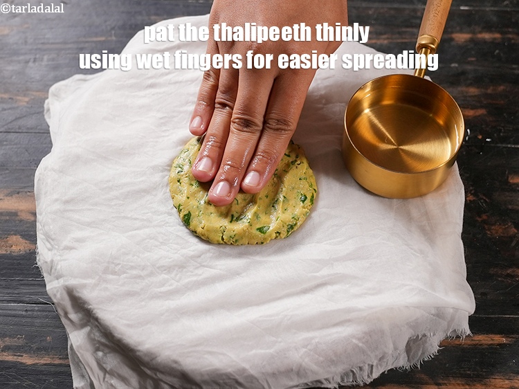 Step 27 – Pat the thalipeeth thinly using wet fingers for easier spreading.&nbsp;