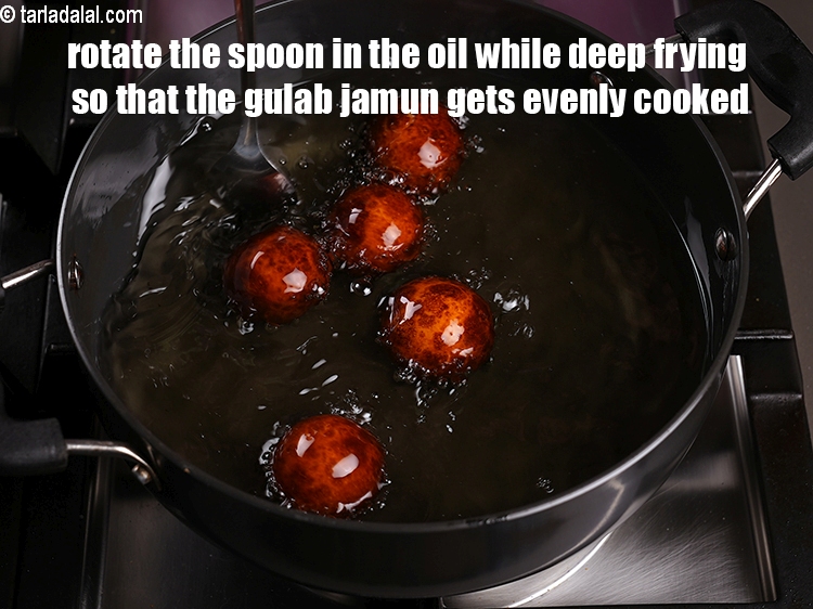 Step 27 – Rotate the spoon in the oil while deep frying so that the gulab jamun gets …