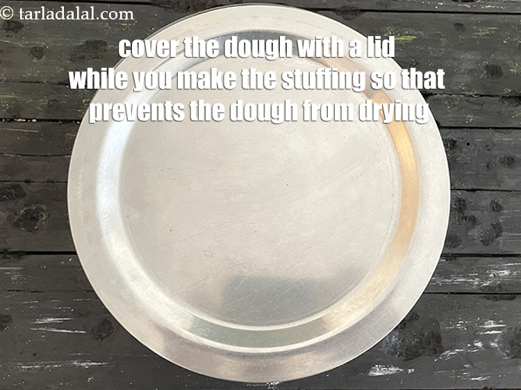 Step 38 – Cover the dough with a lid while you cook the paratha stuffing. This prevents the …