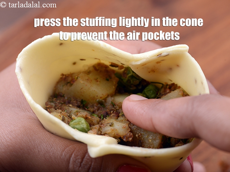 स्टेप 48 – <p>स्टफिंग को कोन में हल्के से दबाएं ताकि एयर पॉकेट …