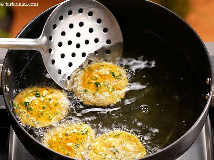 Step 18 – Use a slotted spoon to turn over the masala puris.