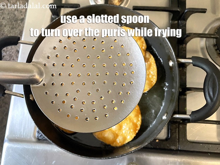 Step 26 – Use a slotted spoon to turn over the masala puris.