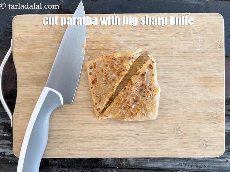 Step 48 – You can cut the <strong>paneer carrot stuffed paratha</strong>&nbsp;with a big sharp&nbsp;knife also.