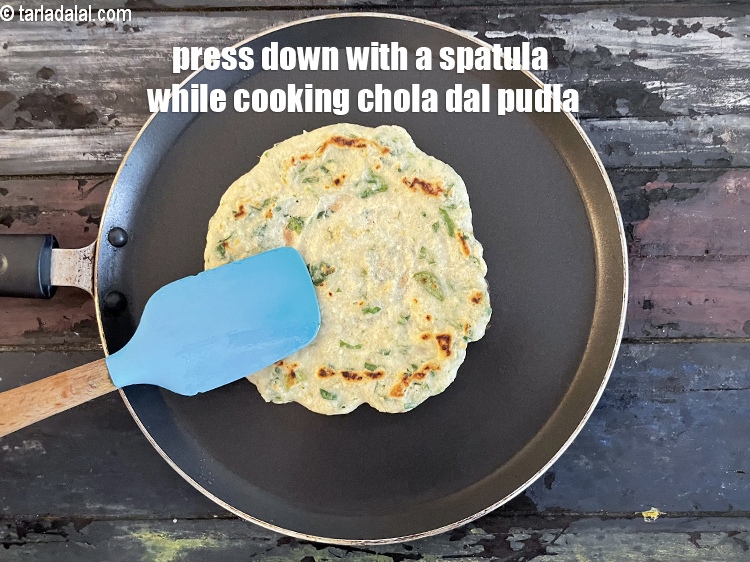 Step 29 – Press down with a spatula while cooking the chola dal pudla.