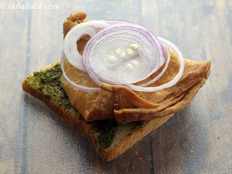 स्टेप 6 – समोसे के ऊपर २ प्याज के स्लाइस अरेन्ज करें।