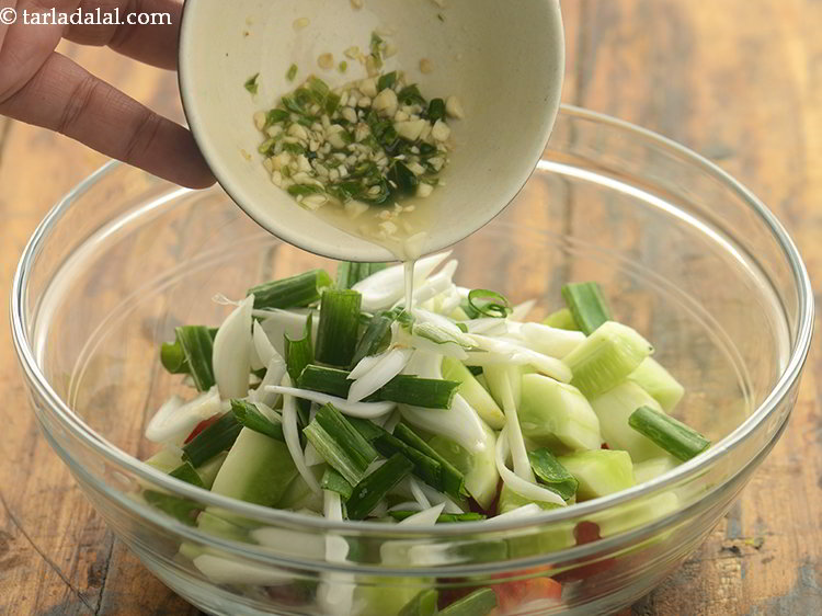 स्टेप 9 – तैयार ड्रेसिंग को <strong>टमाटर ककड़ी और प्याज के सलाद</strong> के …