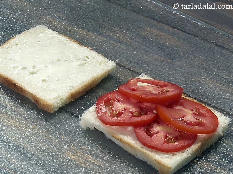 स्टेप 6 – चीज़ स्प्रैड लगाई हुइ एक ब्रेड स्लाइस पर ४ टमाटर …
