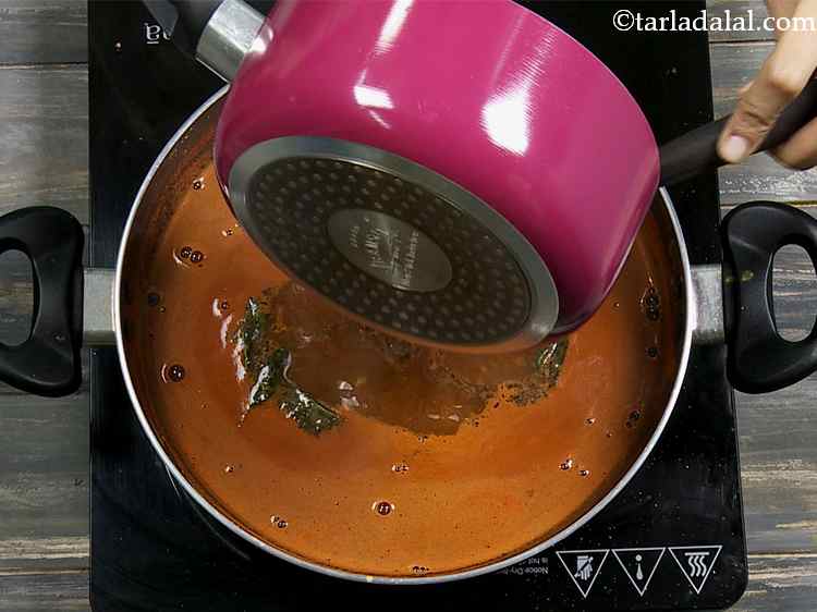 Step 24 – Pour the tempering over the boiling rasam and mix well.