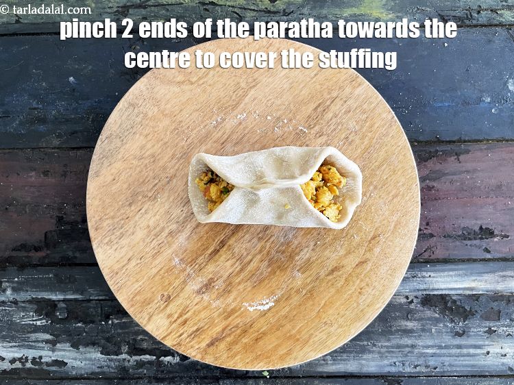Step 51 – Pinch 2 ends of the paratha towards the centre. We are going to make a …