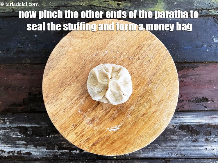 Step 52 – Now pinch the other ends of the paratha to seal the stuffing and form a …