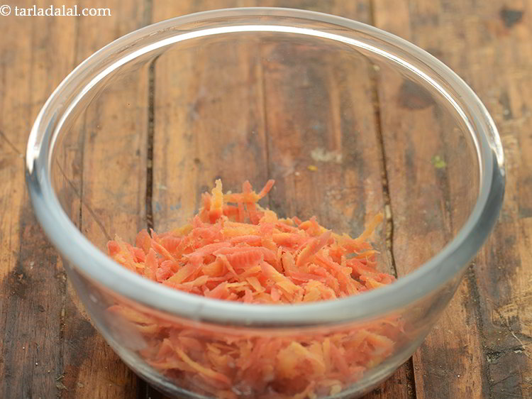 Step 6 – Further, for the orange layer take grated carrot in another deep bowl.&nbsp;