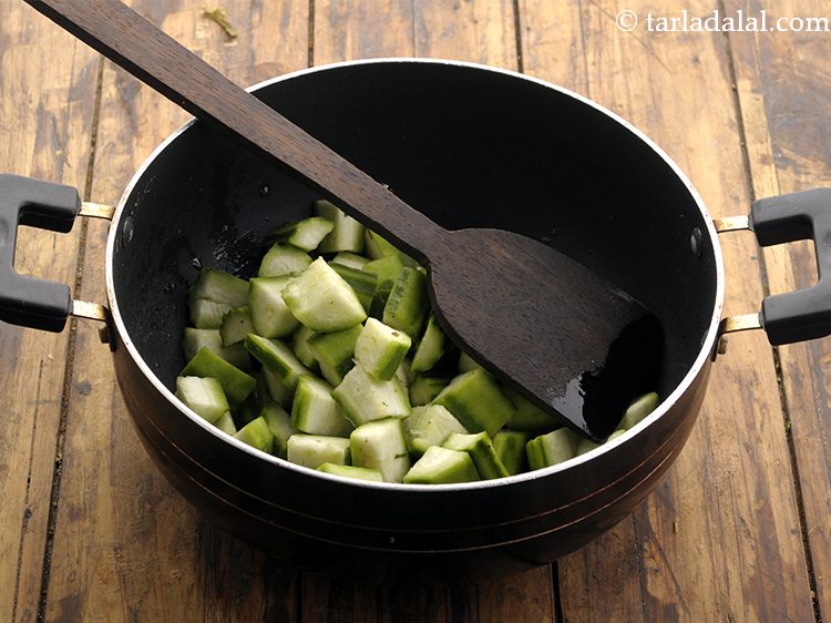 Step 18 – When the seeds crackle, add the ridge gourd.