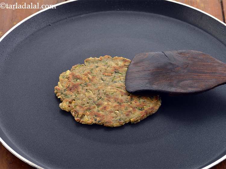 Step 21 – Cook till golden brown spots appear on both the sides. Brush your <strong>Upvaas thalipeeth</strong> with …