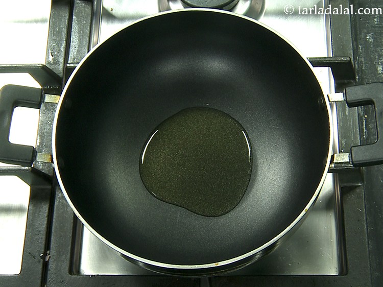Step 19 – To prepare <strong>Maharashtrian Vangi Bath</strong>, heat the oil in a deep non-stick pan.