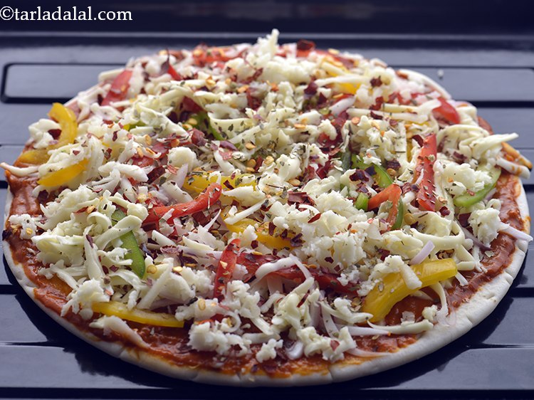 Step 67 – Place it on a baking tray and bake the <strong>veg pizza</strong> in a pre-heated oven …