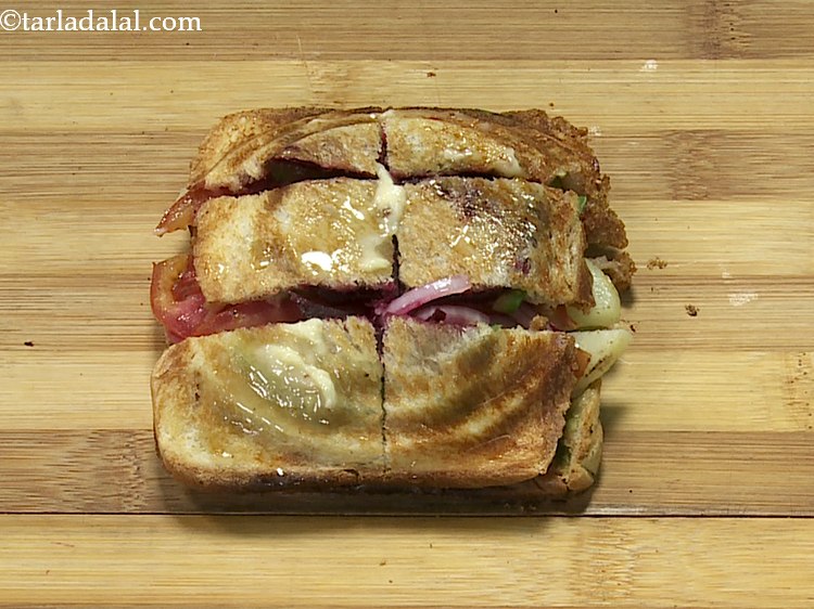 स्टेप 20 – एक प्लेट पर <strong>टोस्टेड वेज सैंडविच</strong> रखें और इसके ऊपर …