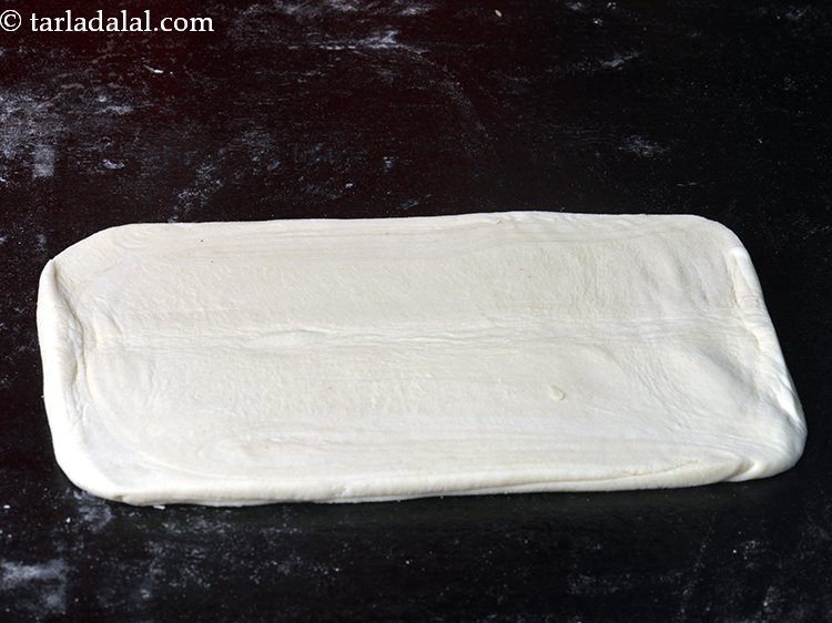 Step 20 – Dust the flat surface once again with a little plain flour. Place one halve of …