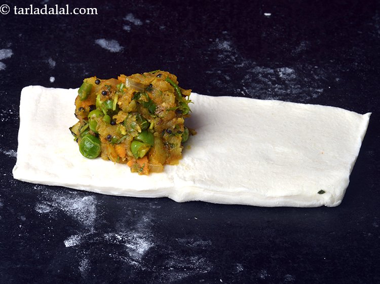 Step 23 – Place one rectangle on a clean, dry surface and place a portion of the veg …