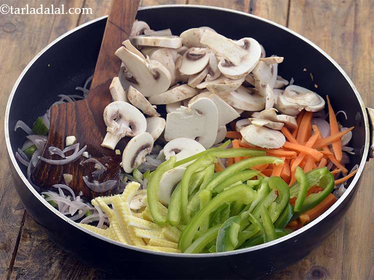 स्टेप 21 – शिमला मिर्च डालें। <strong>चाउमीन</strong> को अधिक रंगीन बनाने के लिए …