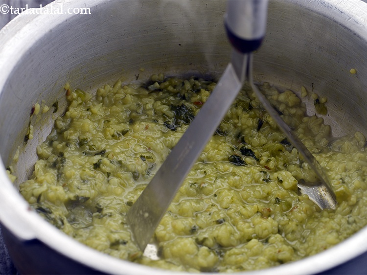 Step 27 – Mash the <strong>Dalia Khichdi</strong> slightly using a potato masher if required to get the right …