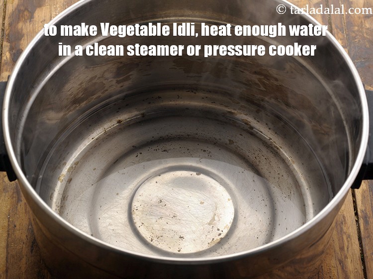 Step 23 – <meta charset="UTF-8" />To make&nbsp;<strong>Vegetable Idli ,&nbsp;</strong>heat enough water in a clean steamer or pressure cooker.&nbsp;<br …