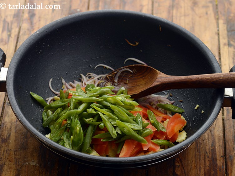 स्टेप 12 – तिरछी कटी हुई और आधी उबाली हुई फण्सी डालें। इसे …