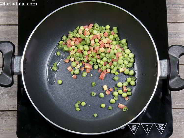 Step 2 – Add the mixed vegetables to the hot oil. We have used french beans, carrots and …