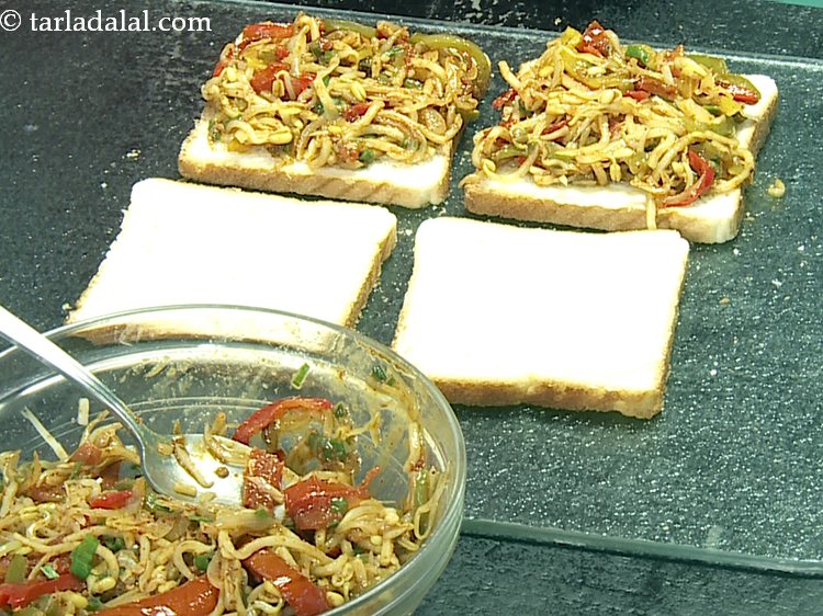 Step 26 – Top 2 buttered bread slices with a portion of the<strong> noodle stuffing</strong>. Spread it evenly.&nbsp;