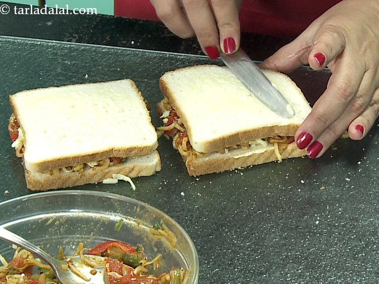 Step 29 – Again spread &frac12; tsp of butter on each <strong>noodles masala sandwich</strong> and press it lightly.