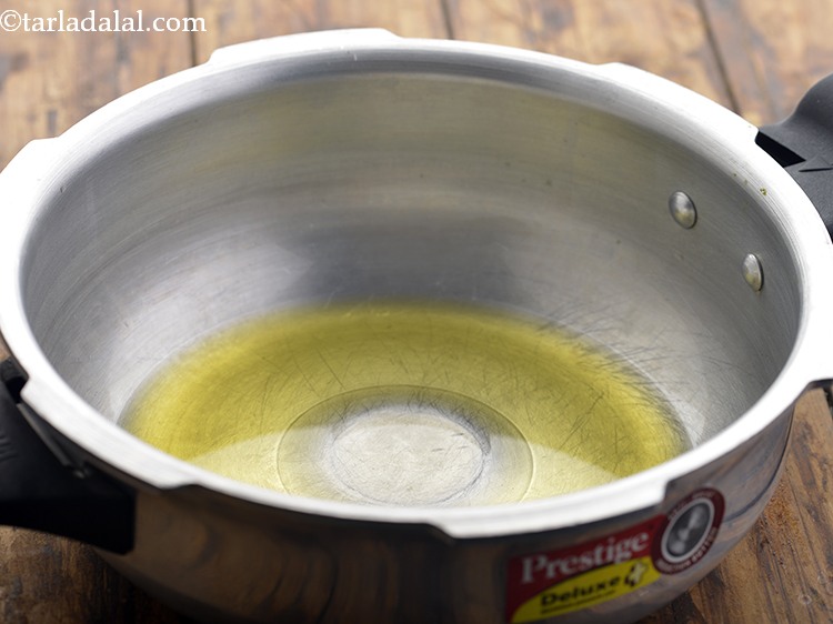 Step 10 – For preparing the&nbsp;<strong>Vegetable Panchmel Khichdi</strong>, heat the ghee in a pressure cooker. Making the panchmel …