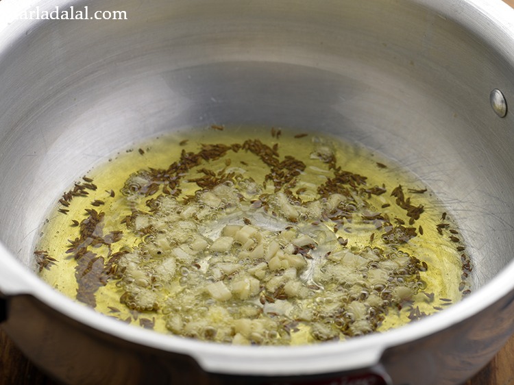 Step 12 – When the seeds crackle, add garlic.