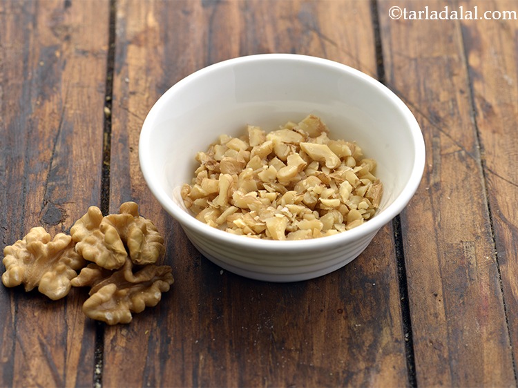 Step 9 – Take 2 to 3 walnuts and finely chop them on a chopping board using a …
