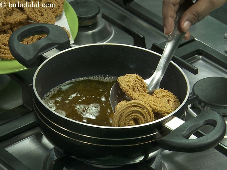 स्टेप 34 – चकली को मध्यम आंच पर डीप फ्राई करें, जब तक …