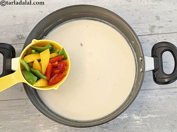 Step 14 – Add&nbsp;<meta charset="UTF-8" />3/4 cup&nbsp;<a href="glossary-sliced-capsicum-165i">sliced coloured capsicum</a>&nbsp;(red , yellow and green).&nbsp;Rich in&nbsp;<a href="https://www.tarladalal.com/recipes-for-Vitamin-C-Rich-Indian-Recipes-804">vitamin C</a>,&nbsp;<a href="https://www.tarladalal.com/recipes-using-capsicum-163">capsicum</a>&nbsp;protect …