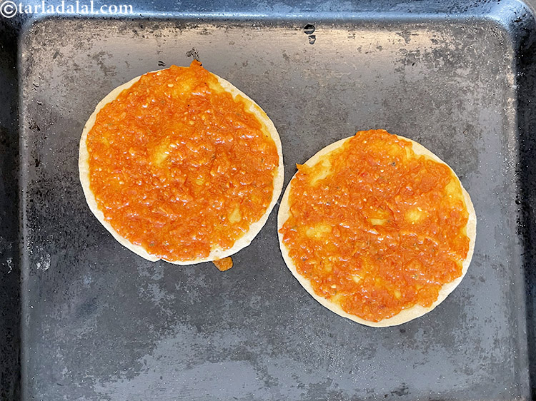 Step 32 – Top with 1/4 cup <a href="https://www.tarladalal.com/homemade-pizza-sauce-with-fresh-tomatoes-3250r">homemade pizza sauce</a> on each pizza base.&nbsp;