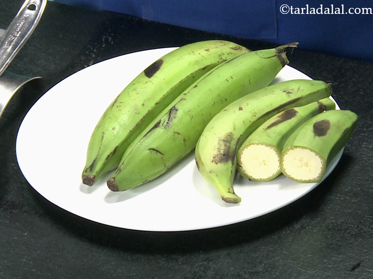 Step 5 – Meanwhile, make light slits on the raw Kerala banana peels at equal distance while taking …