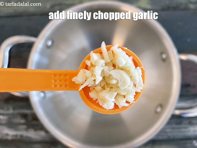 Step 4 – <p>Add 2 tsp&nbsp;finely&nbsp;<a href="glossary-chopped-garlic-790i">chopped garlic (lehsun)</a>. <i><u>If you are Jain, you can skip adding garlic.</u></i></p>