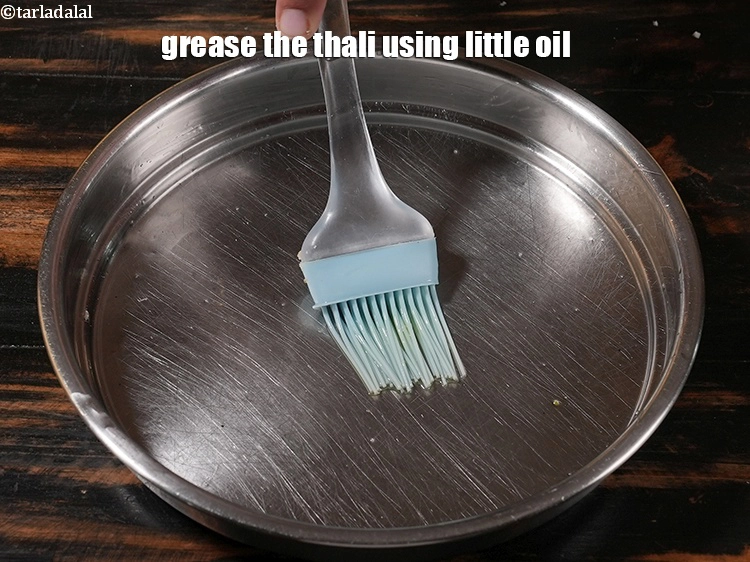 Step 7 – <p>Grease the thali using little oil.</p>