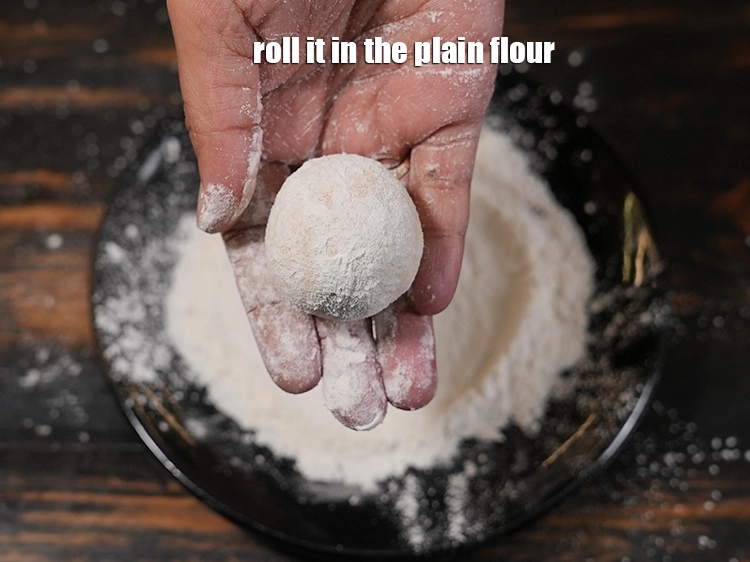 Step 11 – <p>Roll it in the <a href="https://www.tarladalal.in/glossary-plain-flour-maida-188i"><u>plain flour (maida)</u></a>. The maida provides a crispy brown outer …