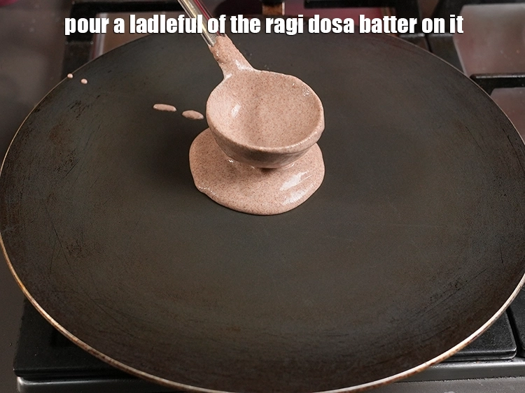 Step 18 – <p>Pour a ladleful of the ragi dosa batter on it.</p>