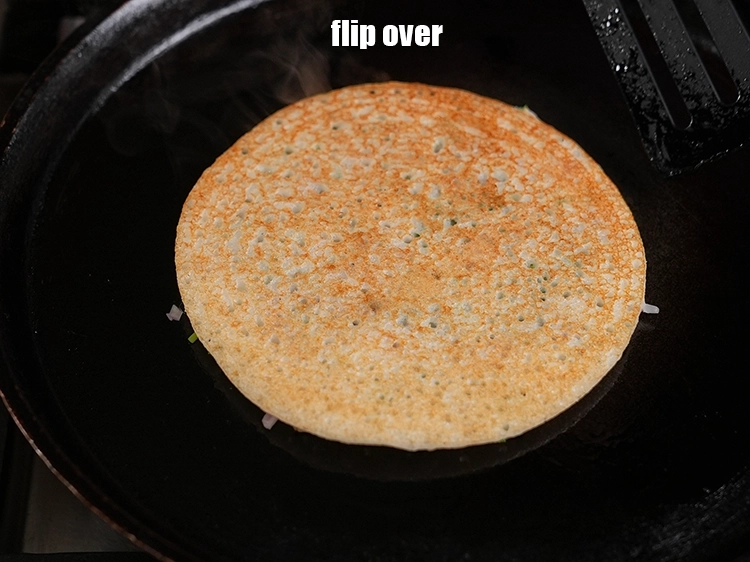 Step 42 – <p><span style="background-color:rgb(255,255,255);color:rgb(0,0,0);">Flip the uttpam over with a spatula.</span></p>