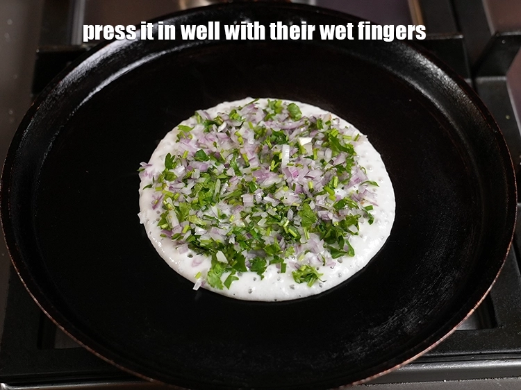 Step 52 – <p><span style="background-color:rgb(255,255,255);color:rgb(0,0,0);">Usually vendors spread the topping over the&nbsp;uttapam&nbsp;batter and press it in well with their …
