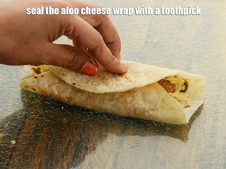Step 44 – <p>Seal the <strong>aloo cheese wrap</strong> with a toothpick.</p>