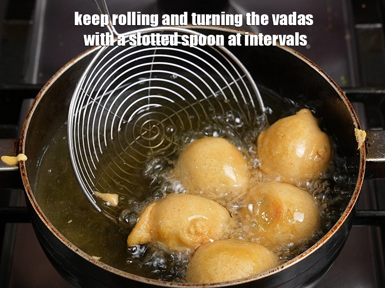 Step 17 – <p>Keep rolling and turning the vadas with a slotted spoon at intervals.</p>