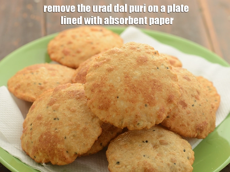 Step 24 – <p>Remove the <strong>urad dal puri</strong> on a plate lined with absorbent paper. Similarly, deep fry …