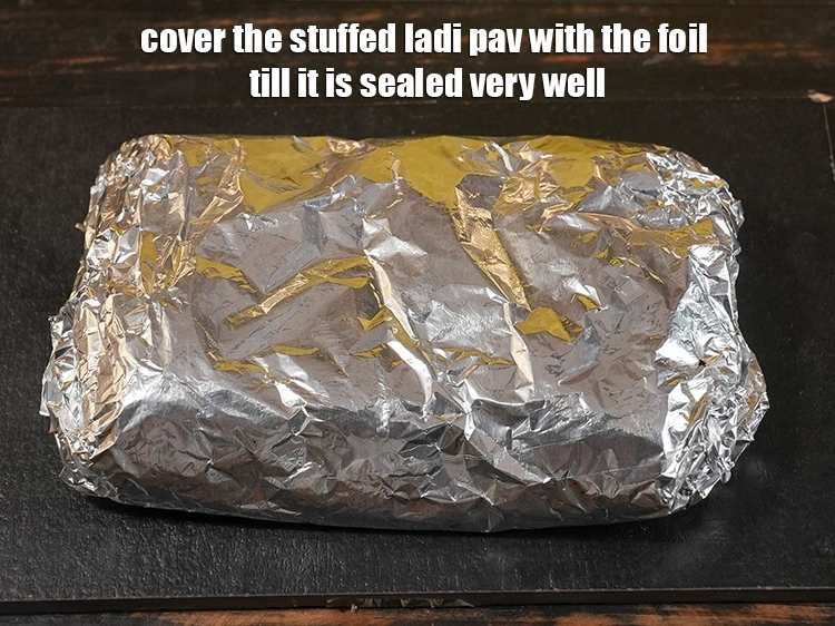 Step 21 – <p><span style="background-color:rgb(255,255,255);color:rgb(0,0,0);">Cover the stuffed ladi pav with the foil till it is sealed very well.</span></p>