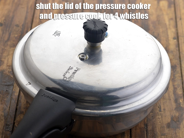 Step 14 – <p>Shut the lid of the pressure cooker and pressure cook for 4 whistles.</p>